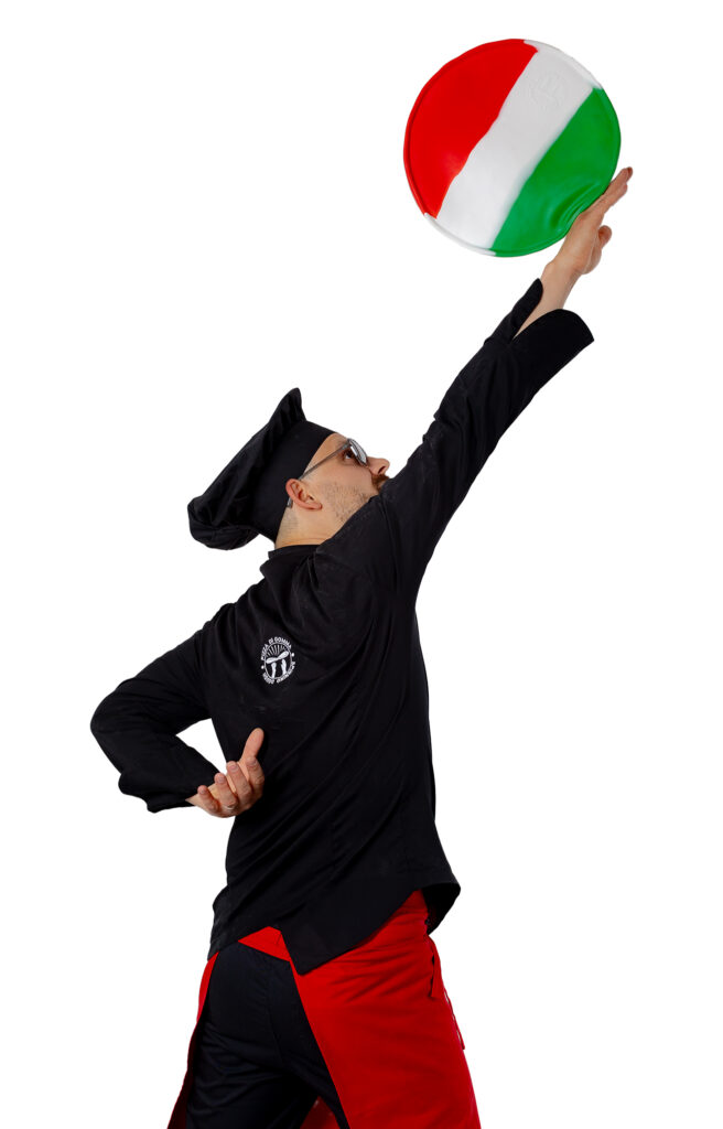 A pizzaiolo tossing a pizza in the colors of the Italian flag